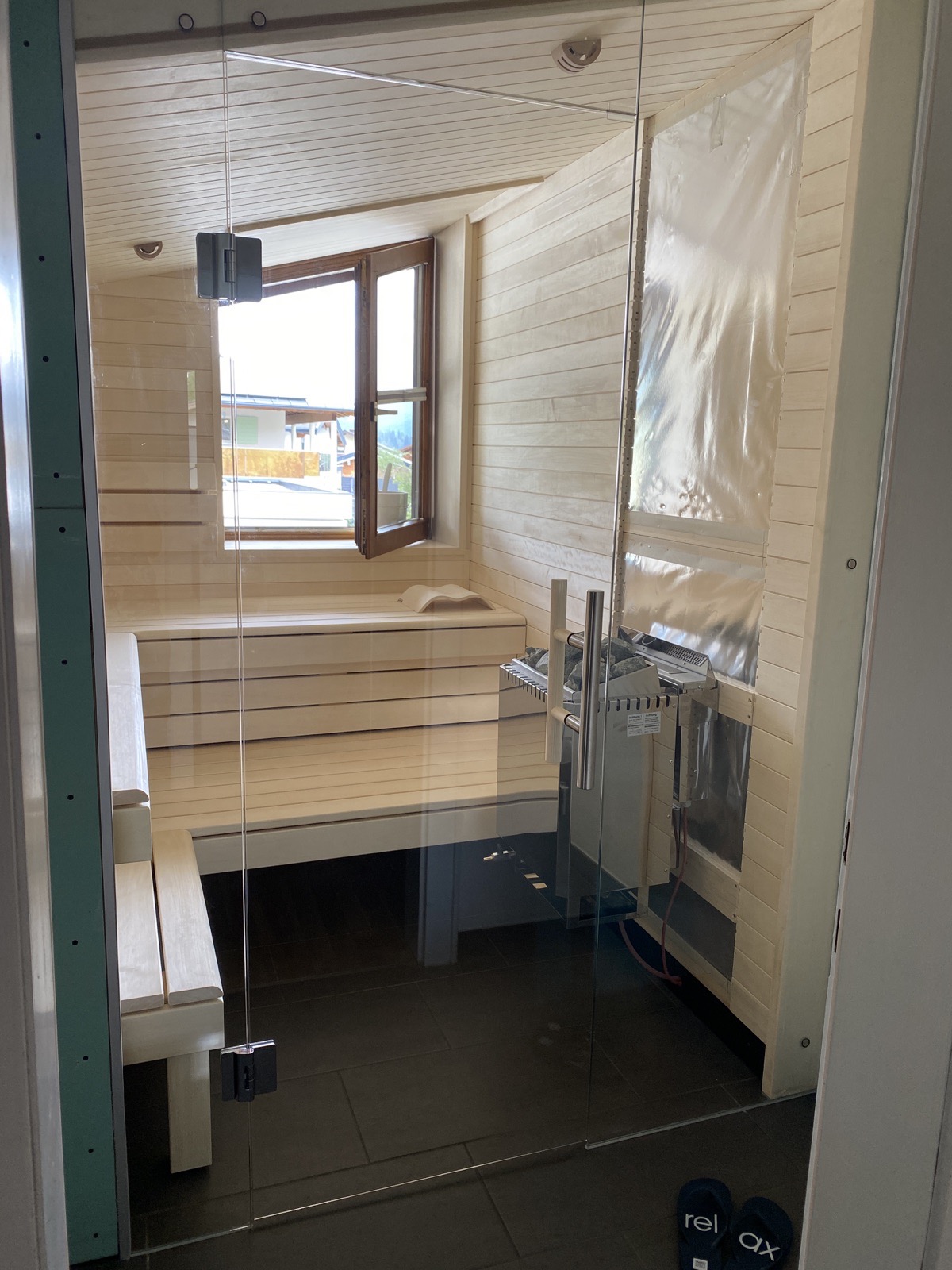 Reales privates Sauna-Projekt mit Glasfront, Ofen und heller Holzverkleidung