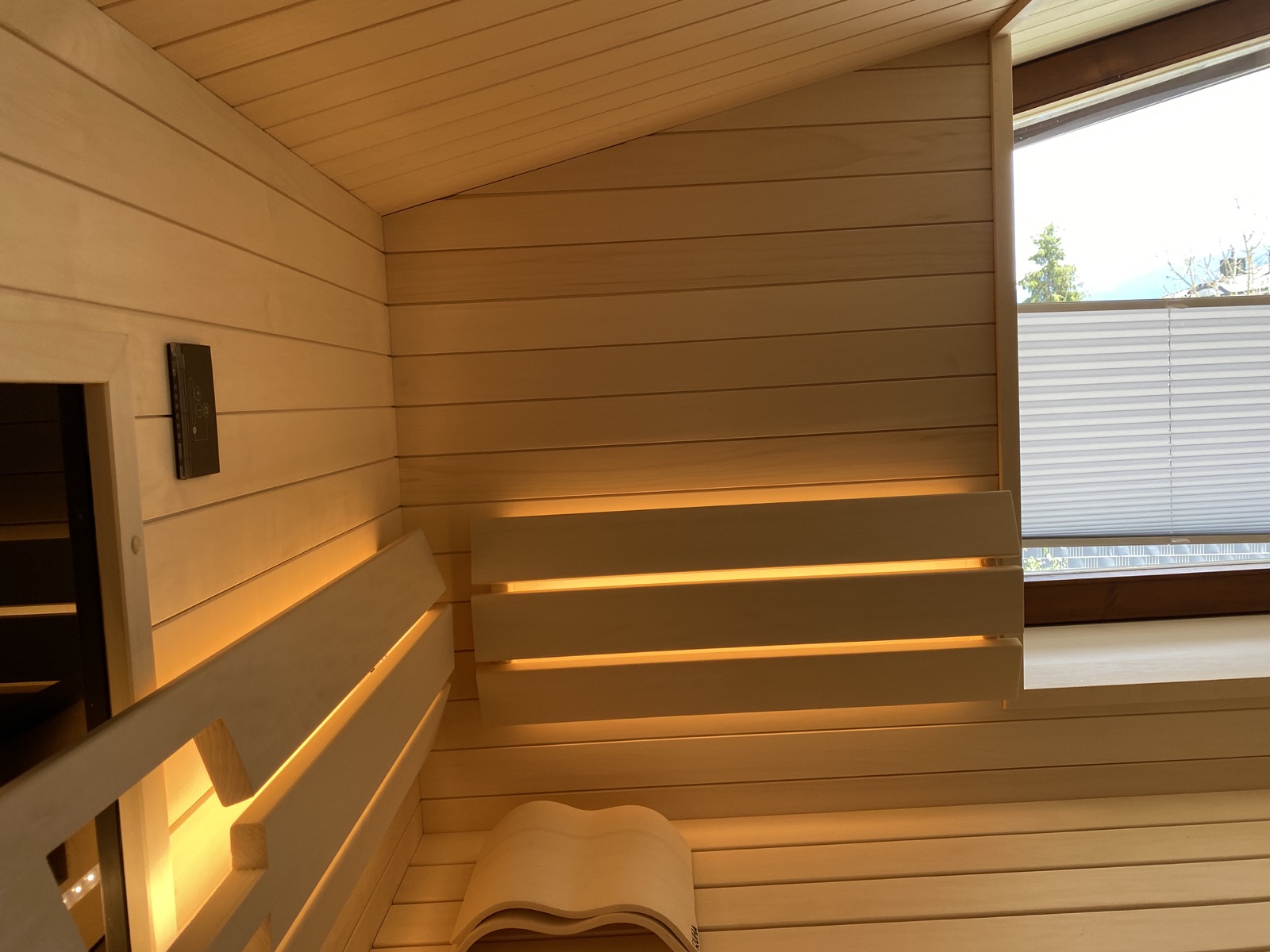 Holzbank mit warmem Licht in einer real eingebauten privaten Sauna